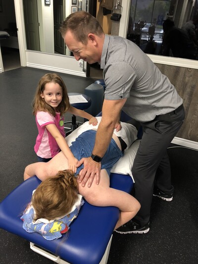 A physical therapist providing a gentle pediatric manual therapy adjustment at Define Wellness in San Juan Capistrano.